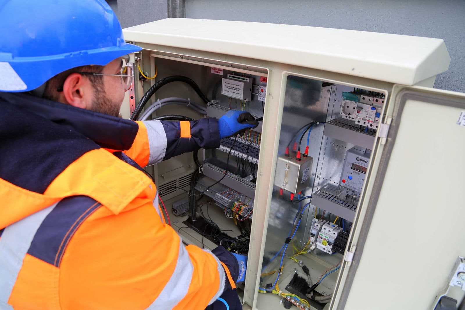 Electrician in front of an outdoor panel